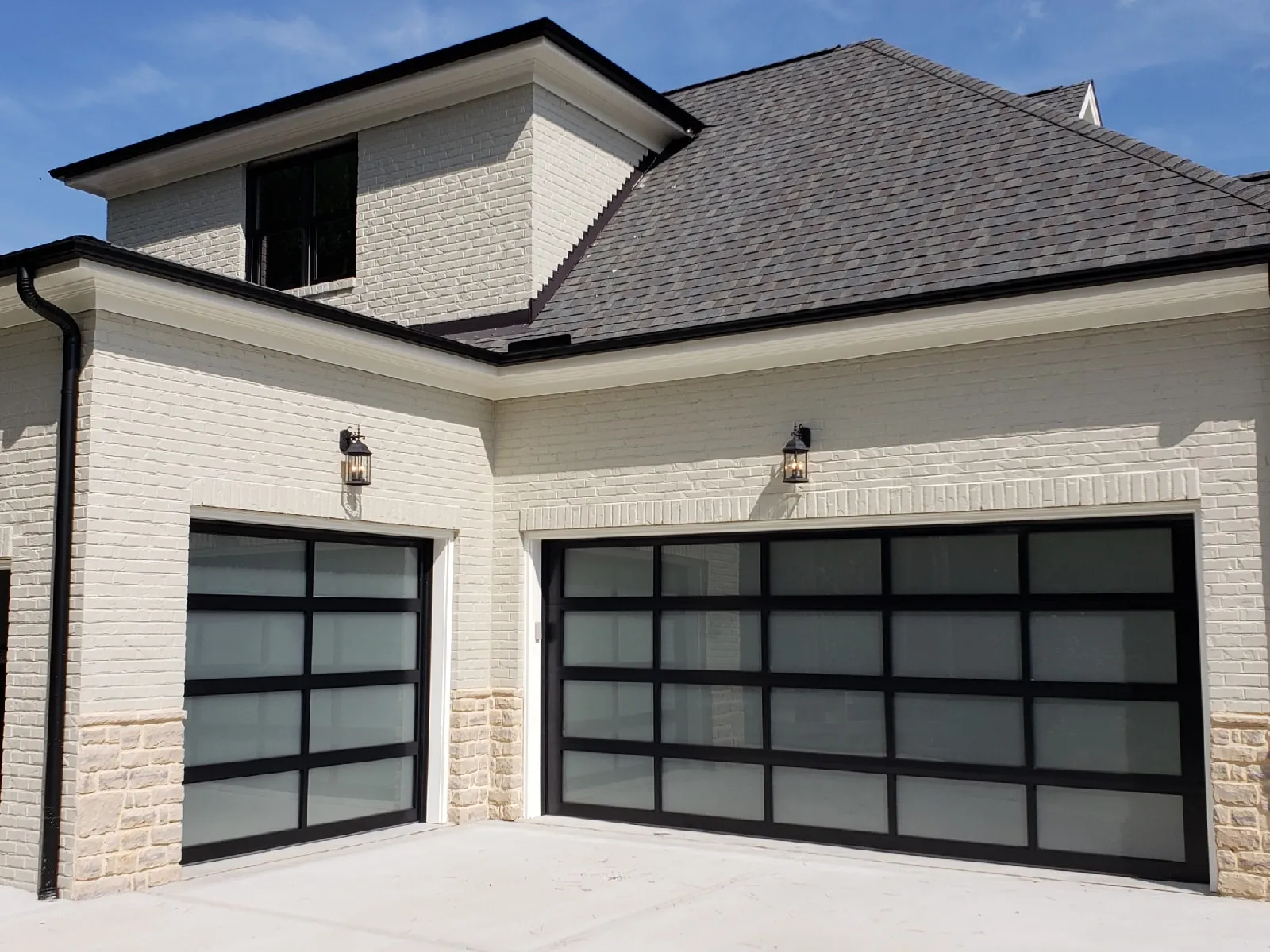 Amarr Classica full-view aluminum garage door on white brick home