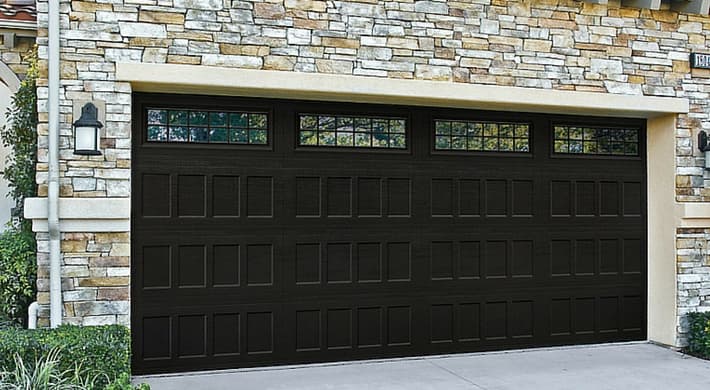 Amarr Hillcrest black raised panel garage door on stone home
